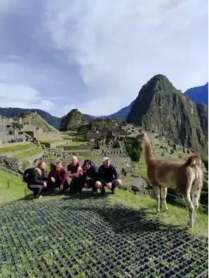 Turistas posando para foto en Machu Picchu con una Llama | Happy Llamas Travel