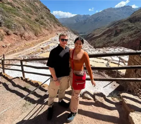 Turistas posando para foto en Salineras de Maras Cusco | Happy Llamas Travel